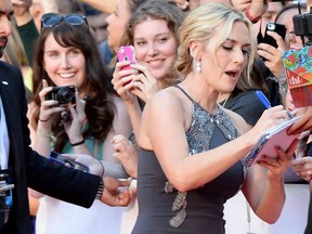 Actor Kate Winslet signs autographs for spectators as she arrives on the red carpet at the gala for the film "The Dressmaker," at the 2015 Toronto International Film Festival in Toronto on Monday, Sept. 14, 2015. THE CANADIAN PRESS/Frank Gunn