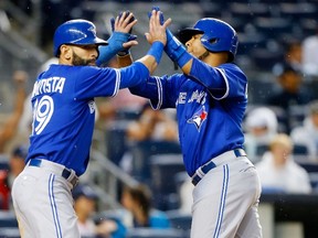 Edwin Encarnacion and Jose Bautista of the Toronto Blue Jays celebrate after both scored against the New York Yankees at Yankee Stadium on September 12, 2015 in New York. (Jim McIsaac/Getty Images/AFP)