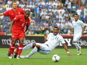 Canada's Julian De Guzman (left) and Honduras' Carlo Costly vie for the ball during World Cup qualifying for Brazil 2014 in San Pedro Sula, Honduras on Oct. 16, 2012. Canada takes on Honduras in a World Cup qualifier in Vancouver on Nov. 13. (AFP PHOTO/Orlando Sierra/Files)