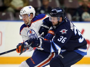 Edmonton's Anton Sleypshev is checked by Winnipeg's John Morrisey Monday in Penticton (Perry Mah, Edmonton Sun).