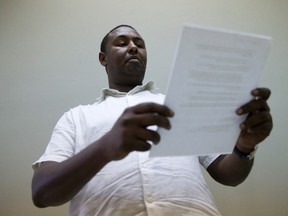 Deeq Abdi, executive director of the African Community Council, reads a letter regarding the loss of federal funding for his organization at the ACC office on Elizabeth Street in London, Ont. on Tuesday August 4, 2015. (CRAIG GLOVER, The London Free Press)