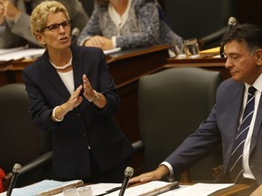 Ontario Liberal Premier Kathleen Wynne (L) speaks as Charles Sousa, Minister of Finance, listens on as the Ontario Legislature it is back in session on Monday September 14, 2015. (Jack Boland/Postmedia Network)