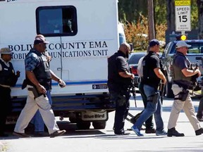 Law enforcement walk across the Delta State University campus to search for an active shooter in connection with a the shooting of history professor Ethan Schmidt in his office in Cleveland, Miss., Monday, Sept. 14, 2015. The suspect in the shooting has not yet been identified and remains at large. (AP Photo/Rogelio V. Solis)