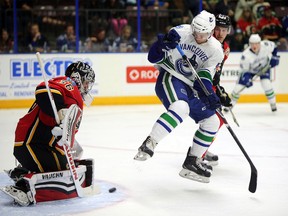 Vancouver Canucks' Dane Fox of Thamesville tries to jump out of the way of the puck in front of Calgary Flames goalie Jon Gilles during the second period at the Young Stars Classic on Sept. 14, 2015, in Penticton, B.C. Fox scored in the Canucks' 3-2 overtime win. They finished the tournament with a 2-1 record. (PERRY MAH/Postmedia Network)