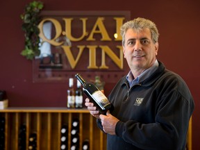 Roberto Quai holds a bottle of his merlot wine in the showroom at Quai du Vin, his winery near Sparta, one of the stops on the Doors Open tour Saturday.