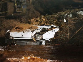 A crushed car is uncovered as residents of Hildale, Utah and Colorado City, Ari., work to clean debris off of a bridge area after a flash flood on Tuesday, Sept. 15, 2015 in Colorado City, Ariz. (Scott G Winterton/The Deseret News via AP)