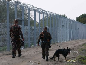 File photo of Hungarian soldiers walk along a fence on the border crossing point from Serbia into the country, near Roszke, Hungary September 13, 2015.    REUTERS/Laszlo Balogh