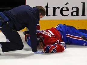 A Canadiens therapist tends to forward Max Pacioretty after he was hit into a glass stanchion by Bruins defenceman Zdeno Chara on March 8, 2011. Pacioretty suffered a broken vertebra and severe concussion on the play. (Shaun Best/Reuters/Files)