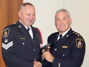 Chatham-Kent police Chief Gary Conn, right, presented Staff Sgt. Brian Biskey with his badge and warrant card after announcing the 30-year veteran of policing was promoted to the rank of inspector during the Chatham-Kent Police Services Board meeting on Tuesday September 15, 2015 in Chatham, Ont. (Vicki Gough, The Daily News)