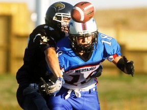 Bow Valley Bobcats Thomas Cameron bats away the ball from a Pincher Creek Mustangs receiver, Logan Kaach, during their exhibition game at Spray Lakes Legacy Field.