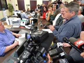 Rowan County Deputy Clerk Brian Mason, left, asks Shannon Wampler-Collins, right and her partner Carmen Wampler-Collins to double check their marriage license at the Rowan County Judicial Center in Morehead, Ky. Monday, Sept. 14, 2015. Rowan County Clerk Kim Davis announced earlier that her office will issue marriage licenses under order of a federal judge, but will not have her name or office listed. (AP Photo/Timothy D. Easley)