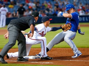 Cliff Pennington of the Toronto Blue Jays is safe at first base under the tag of Daniel Castro of the Atlanta Braves after hitting a RBI single at Turner Field in Atlanta on Sept. 15, 2015. (Kevin C. Cox/Getty Images/AFP)