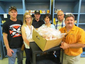Farmers, from left, Lee McMurphy, Kelsey Ottens, Martin DeKoning, Dorine DeKoning and Jack Koetsier gather with Myles Vanni, executive director of the Inn of the Good Shepherd, around a box of chicken on Wednesday September 16, 2015 in Sarnia, Ont. Donations from local chicken and hatching egg farmers have been helping local food bank provide chicken to families in need. Paul Morden/Sarnia Observer/Postmedia Network