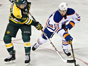 Cole Sanford tries to block a pass from University of Alberta's Jordan Hickmott during the third period of the Edmonton Oilers rookies' exhibition hockey game against the University of Alberta Golden Bears at Rexall Place on Wednesday. (Codie Mclachlan, Edmonton Sun)