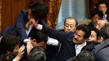 Japanese ruling and opposition lawmakers scuffle at the Upper House's ad hoc committee session for the controversial security bills at the National Diet in Tokyo on Sept. 17, 2015.  (AFP PHOTO/Yoshikazu Tsuno)