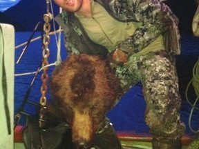 An image of NHLer Clayton Stoner holding the severed head of a grizzly.