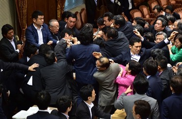 Japanese ruling and opposition lawmakers scuffle at the Upper House's ad hoc committee session for the controversial security bills at the National Diet in Tokyo on Sept. 17, 2015. (AFP PHOTO/Yoshikazu Tsuno)