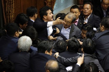 Japanese lawmakers scuffle during a committee voting of security bills at the upper house in Tokyo, Thursday, Sept. 17, 2015. (AP Photo/Eugene Hoshiko)