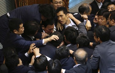 Japanese lawmakers scuffle during a committee voting of security bills at the upper house of the parliament in Tokyo, Thursday, Sept. 17, 2015. (AP Photo/Eugene Hoshiko)