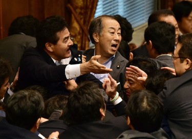 Japanese ruling and opposition lawmakers scuffle at the Upper House's ad hoc committee session for the controversial security bills at the National Diet in Tokyo on Sept. 17, 2015. (AFP PHOTO/Yoshikazu Tsuno)
