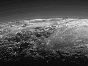 This July 14, 2015 photo released by NASA on Thursday, Sept. 17, 2015 shows the atmosphere and surface features of Pluto, lit from behind by the sun. It was made 15 minutes after the New Horizons' spacecraft's closest approach. (NASA/JHUAPL/SwRI via AP)
