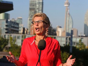 Premier Kathleen Wynne speaks to media after she went on a morning run through the newly created park by the Pan Am athletes village at the mouth of the Don River in Toronto with Liberal candidate Bill Morneau Wednesday September 16, 2015. (Michael Peake/Toronto Sun)
