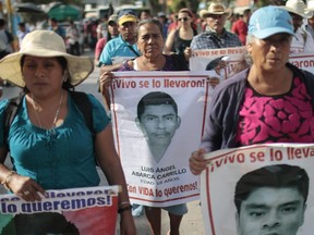 Relatives of the 43 missing students protest with their portraits at the central square in Chilpancingo, Guerrero State, Mexico on September 15, 2015. Next September 26 will mark the first anniversary of the disappearance of 43 Mexican students from Ayotzinapa. In the past days independent foreign investigators refuted the Mexican government's conclusion that the students abducted last year were incinerated in a landfill. AFP PHOTO/Pedro PARDO