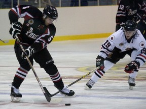 Lambton Shores Predators defenceman Calvin Hughson protects the puck from Sarnia Legionnaires forward Joey Zappa during the Greater Ontario Junior Hockey League game at Sarnia Arena Thursday night. (Terry Bridge, The Observer)