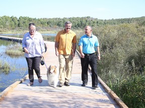 Franco Mariotti, centre, chats with Lin Gibson, chair of Conservation Sudbury, and Ward 1 Coun. Mark Signoretti as they walk with Rusty at the Beaver Pond Trail at the Lake Laurentian Conservation Area in Sudbury, Ont. on Thursday September 17, 2015. Mariotti was named the 2015 patron of the Lake Laurentian Conservation Area. Gino Donato/Sudbury Star/Postmedia Network