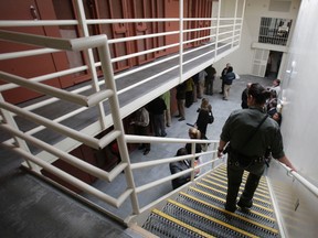 In this Aug. 17, 2011 file photo, reporters inspect one of the two-tiered cell pods in the Security Housing Unit at the Pelican Bay State Prison near Crescent City, Calif. Inmates say newly imposed welfare checks in the SHU have created excessive noise by the guards, causing California prison officials to hand out earplugs to inmates and tell the guards to walk softly while going about their rounds.(AP Photo/Rich Pedroncelli, file)