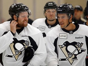 Pittsburgh Penguins' Phil Kessel, left, skates with Adam Clendening, right, and Sergei Gonchar, center, as they warm up during NHL hockey training camp, Friday, Sept. 18, 2015, in Cranberry Township, Pa. (AP Photo/Keith Srakocic)