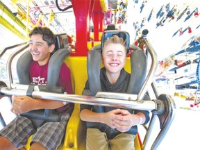 Quinn Wenger and Gabe Gurd ride the Banzai, a looping ride that sees riders get some serious hang time, at the Western Fair in London. (CRAIG GLOVER, The London Free Press)