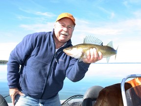 Neil with a “fat and feisty” Pigeon Lake walleye. His dog Penny looks on. (NEIL WAUGH PHOTO)