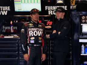 Martin Truex Jr., driver of the #78 Furniture Row/Visser Precision Chevrolet, left, talks with crew chief Cole Pearn during in the garage area practice for the NASCAR Sprint Cup Series Axalta 'We Paint Winners' 400 at Pocono Raceway on June 6, 2015 in Long Pond, Pennsylvania. (Chris Trotman/Getty Images/AFP)