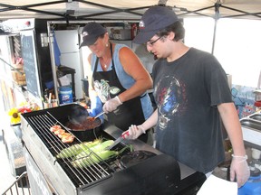 Rhonda Evans, left, and Sam Miller start cooking for the day in the new Glocca Morra Grill at the fall fair in Kingston on Friday. The grill focuses on local produce. (Michael Lea/The Whig-Standard)