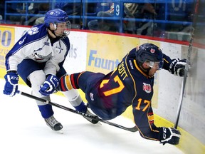 Sudbury Wolves rookie blueliner Brandon Bastasin dumps Barrie Colts forward Justin Scott into the boards during OHL exhibition play at Sudbury Community Arena on Friday night.