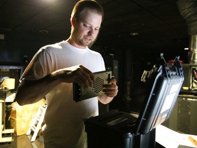 Chris Gagnon, strategic partnerships development office with Cinefest Sudbury, gets set to download the movie Winter onto the server in the projection booth at Silver City in Sudbury, Ont. on Friday, September 18, 2015. Gino Donato/Sudbury Star/Postmedia Network