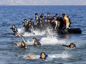 Afghan refugees struggle to swim ashore after their dinghy with a broken engine drifted out of control off the Greek island of Lesbos while crossing a part of the Aegean Sea from the Turkish coast Sept. 19, 2015. REUTERS/Yannis Behrakis