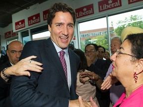 Liberal leader Justin Trudeau is greeted by supporters as he arrives to officially open his 2015 federal election campaign office in the riding of Papineau in Montreal Tuesday, Aug. 11, 2015. THE CANADIAN PRESS/Graham Hughes