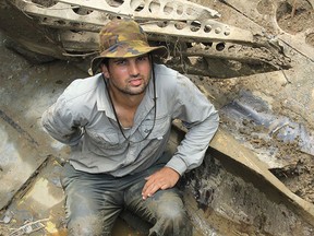 In this 2014 photo provided by Pacific Wrecks, Justin Taylan, founder and director of Pacific Wrecks poses at a Second World War airplane wreck site in Papua New Guinea (PNG).  (Marcus Browning/Pacific Wrecks via AP)