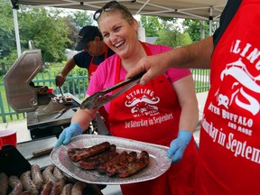 Michelle Gilroy laughs as her husband, Lance, loads her tray with water buffalo sausages during the sixth-annual Water Buffalo Festival Saturday in Stirling. Free admission pushed the crowd past the 1,000 mark in the first hour, with hundreds more passing through during the afternoon. Behind the Gilroys is Dave Smith.