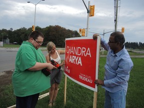 Liberal candidate Chandra Arya (right) puts up a sign on Woodroffe Avenue Saturday, Sept. 19, 2015 along with his volunteers, Warren Arshinoff and Isabelle Grzegorzko.  JULIE BAY/Ottawa Sun