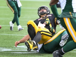 Hamilton Tiger-Cats quarterback Zach Collaros (4) is tackled by Edmonton Eskimos defensive end Mathieu Boulay (77) during the first half of CFL football action in Hamilton, Ontario on Saturday, September 19, 2015. Collaros was injured on the play and left the game. THE CANADIAN PRESS/Peter Power