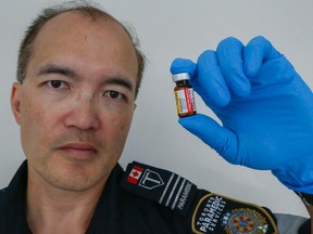 Toronto paramedic Dominic Wong, holds a vile of Naloxone. (Dave Thomas/Toronto Sun)