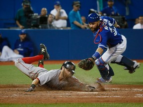 Dustin Pedroia scores safely past Russell Martin at home plate to give the Red Sox the lead as the Toronto Blue Jays eventually lose to the Boston Red Sox  at the Rogers Centre on Saturday. (Stan Behal/Toronto Sun)