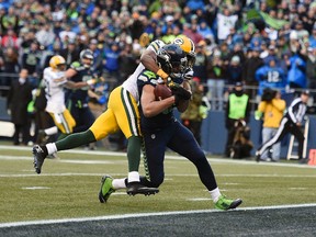 Seattle Seahawks wide receiver Jermaine Kearse (15) catches a 35 yard pass from quarterback Russell Wilson (not pictured) for the game winning touchdown ahead of Green Bay Packers cornerback Tramon Williams (38) during the overtime period in the NFC Championship game at CenturyLink Field on January 18, 2015. (Kyle TeradaéUSA TODAY Sports)