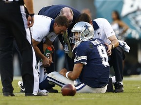 Cowboys quarterback Tony Romo is looked at by medical staff after being injured on a sack against the Eagles yesterday in Philadelphia. Romo suffered a broken collarbone on the play and is expected to be out for several weeks. (AFP)