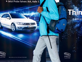 A visitor passes by a Volkswagen advertisement during the Frankfurt Motor Show (IAA) in Frankfurt, Germany, on Sept. 21. Shares in Volkswagen plunged the most in almost six years in early Monday trading after U.S. authorities accused the German carmaker of falsifying emissions data, which means it could face penalties of up to $18 billion. (REUTERS/Ralph Orlowski)
