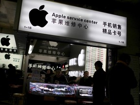 Customers and salespersons are seen at an Apple maintenance service store at a mobile phone market in Shanghai, in this January 24, 2013 file photo. Apple Inc said on Sunday it is cleaning up its iOS App Store to remove malicious iPhone and iPad programs identified in the first large-scale attack on the popular mobile software outlet.  REUTERS/Aly Song/Files