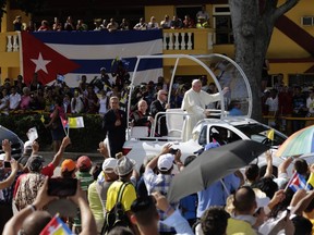 Pope Francis waves from his popemobile as he travels to the Plaza of the Revolution to celebrate Mass in Holguin, Cuba, Monday, Sept. 21, 2015. Francis is the first pope to visit Holguin, Cuba's fourth-largest city. (Ismael Francisco/Cubadebate Via AP)